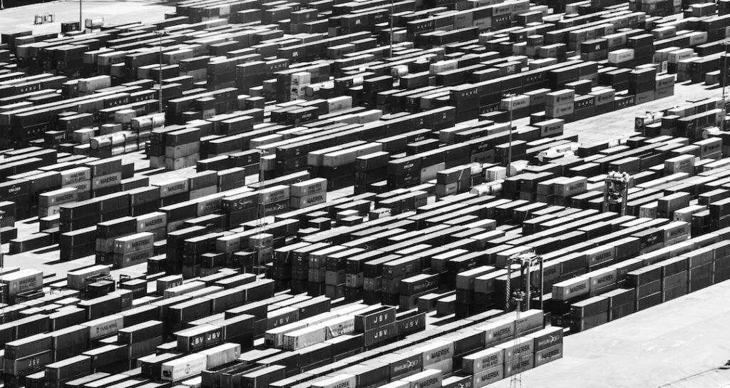 A black and white photo of a warehouse full of boxes.