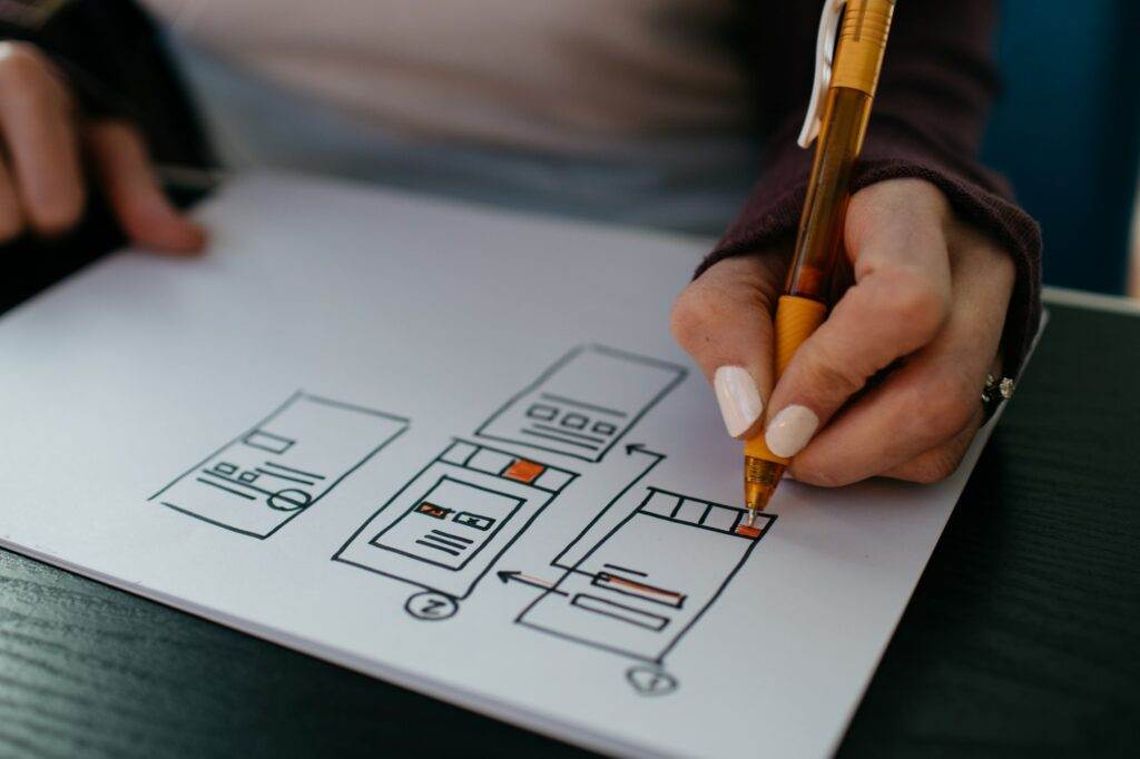 A person drawing a diagram on a piece of paper.